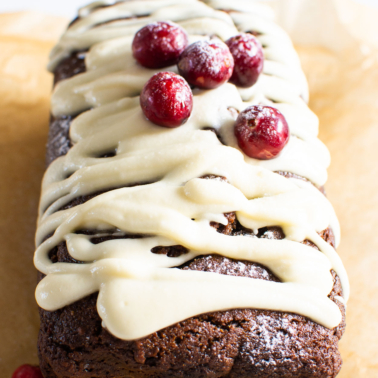 Healthy gingerbread loaf with glaze and cranberries.